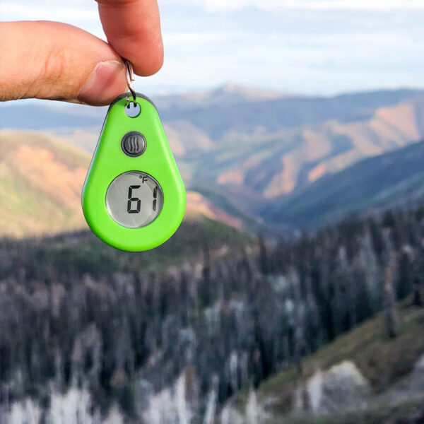Thermodrop-digitale-thermometer-rits Green ThermoDrop thermometer held against a mountain view