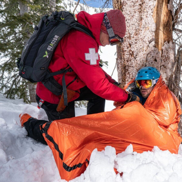 Emergency_Bivvy_Orange_in_use_ski_patroller_rescue_in_snow.jpg SOL - Emergency Bivy